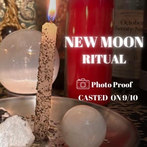 Peut inclure: Une bougie effilée allumée et recouverte d'herbes repose dans un plat en métal argenté avec une sphère blanche lisse et une pierre blanche brute. Une grande bougie pilier rouge brille derrière. Texte : NEW MOON RITUAL, Photo Proof, CASTED ON 9/10.