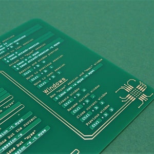 May include: A green printed circuit board with gold-coloured text and lines. The text includes "Windows" and commands for using the "tmux" terminal multiplexer.