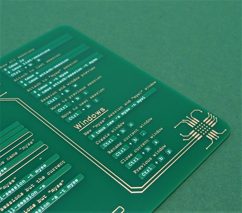 May include: A green printed circuit board with gold-coloured text and lines. The text includes "Windows" and commands for using the "tmux" terminal multiplexer.