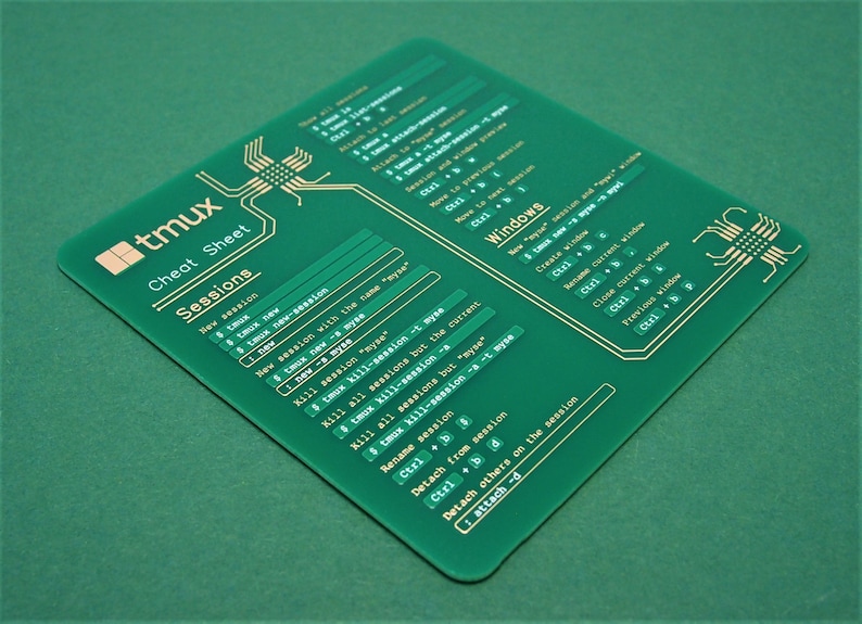 May include: A green plastic cheat sheet with gold text for the tmux terminal multiplexer. The cheat sheet includes commands for sessions and windows.