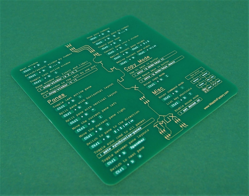 May include: A green printed cheat sheet with gold text outlining keyboard shortcuts for using a tiling window manager. The cheat sheet includes sections for "Panes", "Copy Mode", and "Misc".