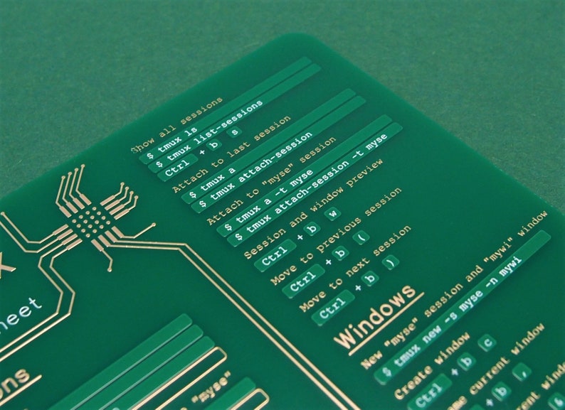 May include: A green printed cheat sheet with gold lettering showing commands for the tmux terminal multiplexer. The commands include "Show all sessions", "Attach to last session", "Attach to "myse" session", "Session and window preview", "Move to previous session", "Move to next session", and "Windows".