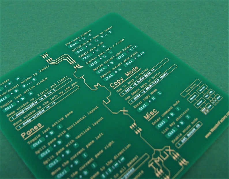 May include: A green printed circuit board with gold lettering showing keyboard shortcuts for the TMUX terminal multiplexer. The board includes shortcuts for panes, copy mode, and misc commands.