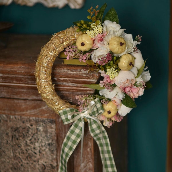 Light pumpkin wreath. A wreath of artificial flowers on the front door. Christmas wreath. Home decoration.