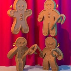 May include: Four gingerbread men cookies, two with a happy face and two with a grumpy face. Two of the gingerbread men are holding candy canes, and two are holding rope.
