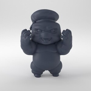 May include: A gray, cartoon-style figurine of a creature with a chef's hat, wearing a white uniform, and making a fist with both hands.