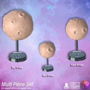 May include: Three 3D printed asteroid models on stands, a large, medium, and small asteroid. The asteroids are a light brown colour with craters. The stands are clear plastic. The text "Large Asteroid", "Medium Asteroid", and "Small Asteroid" is printed below each stand.