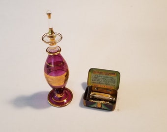 For the ladies' boudoir: an Egyptian art glass perfume dabber and tiny Laurel safety razor