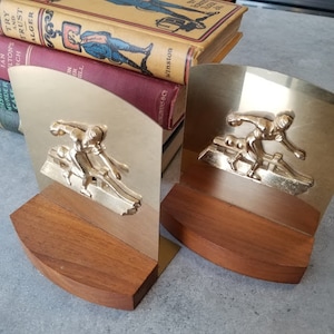 Pair of brass bookends with solid brass cast figures of lady bowling.
