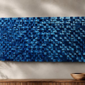 May include: A rectangular wall art piece composed of numerous small, individual wooden blocks arranged in a grid. The blocks are painted in varying shades of deep blue and navy, creating a textured, three-dimensional surface with depth.