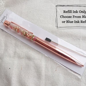 Peut inclure: Stylo en or rose avec des fleurs s&eacute;ch&eacute;es ench&acirc;ss&eacute;es dans le barillet transparent. Le stylo est livr&eacute; avec une recharge d'encre noire et une recharge de remplacement. Recharge d'encre uniquement ! Choisissez entre l'encre noire ou bleue