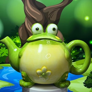 May include: A whimsical ceramic teapot shaped like a frog. The teapot is primarily green with a yellow belly and a flower accent. It features large, expressive eyes and a curved handle, perfect for tea lovers.