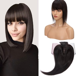 May include: A black human hair clip-in fringe with a straight style. The fringe is shown on a mannequin head and a person wearing it.