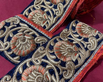 May include: Blue velvet trim with gold and orange embroidery. The trim features a floral design with paisley accents.