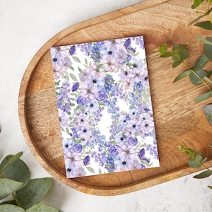 May include: A white card featuring a purple and light purple floral pattern. The flowers are watercolour painted and have a soft, romantic feel.