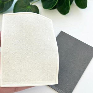 May include: Two white and gray textured silicone mats with a repeating pattern of small circles. The mats are flexible and can be used for baking, crafting, or other projects.