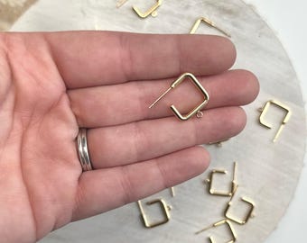 May include: Gold square earring findings with a jump ring. The findings are on a white surface.