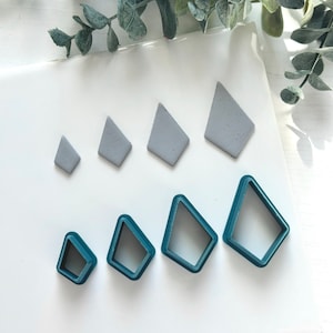 May include: A set of six diamond-shaped polymer clay cutters. The cutters are in two sizes and two colors: gray and teal.