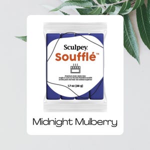 Könnte beinhalten: Eine Packung Sculpey Soufflé Polymer Clay in Midnight Mulberry. Die Packung zeigt einen dunkelblauen Tonblock mit Markennamen und Produktdetails. Es wiegt 48 g. Der Text "Midnight Mulberry" steht darunter.