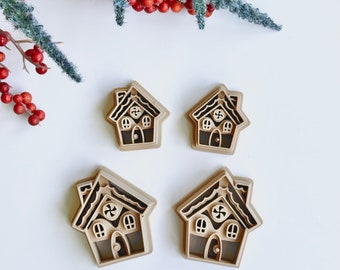 May include: Four gingerbread house cookie cutters, two larger and two smaller, made of brown plastic. The cutters have a detailed design with candy cane accents and windows.