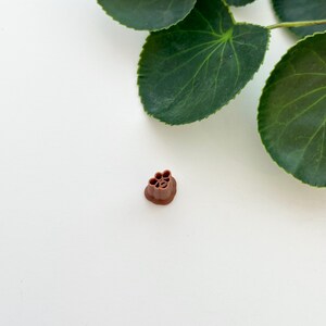 May include: A brown plastic flower-shaped mold for making decorative items.