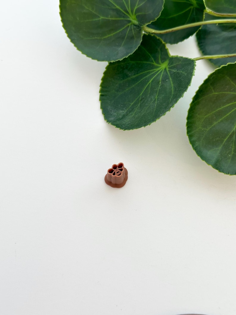 May include: A brown plastic flower-shaped mold for making decorative items.