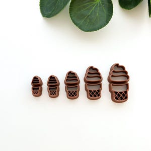 May include: Set of five brown plastic ice cream cone cookie cutters in various sizes.