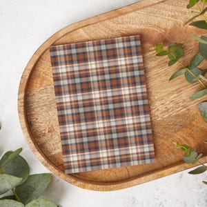 May include: A brown, white, and blue plaid patterned card on a wooden tray.