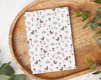 Könnte beinhalten: Eine weiße Karte mit einem sich wiederholenden Muster aus braunen und weißen Hühnern und rosa Blumen. Die Hühner sind in verschiedene Richtungen gewandt und die Blumen sind in verschiedenen Rosatönen gehalten.
