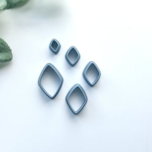 May include: Set of five grey plastic diamond-shaped cookie cutters of varying sizes.