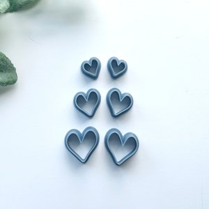 May include: Set of six gray heart-shaped cookie cutters of varying sizes.