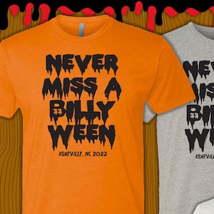 Könnte beinhalten: Ein orangefarbenes Kurzarm-T-Shirt und ein graues Kurzarm-T-Shirt, beide mit schwarzem Text, der NEVER MISS A BILLY WEEN ASHEVILLE, NC 2022 in einer tropfenden Schriftart zeigt. Der Text enthält die Zahl 33 innerhalb des Wortes BILLY.