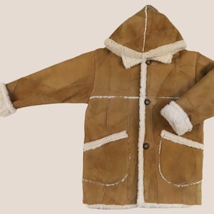 May include: A brown sheepskin coat with a hood and a button closure. The coat has a patchwork design and two pockets.
