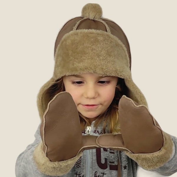 Aviateur cappuccino-beige, bonnet en cuir d'agneau pour garçon et fille avec oreillettes et pompon. Bonnet pratique, doux et léger qui offre une chaleur naturelle