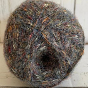 May include: A ball of yarn with a mix of grey, brown, orange, and red colors. The yarn has a fuzzy texture.