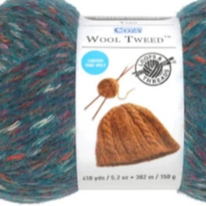 May include: A skein of teal blue yarn with multi-colored flecks. The yarn is labeled "Cozy Wool Tweed" and is 418 yards / 5.2 oz.  The label also shows a brown knitted hat.