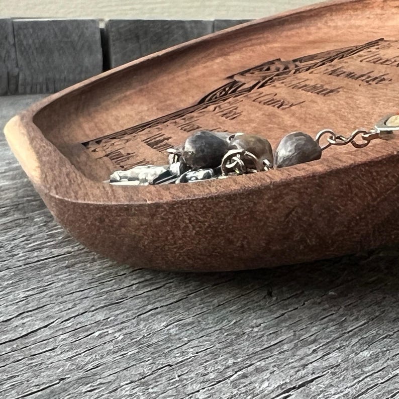 Peut inclure: Un bol en bois avec un motif grav&eacute; et une cha&icirc;ne en argent avec des perles &agrave; l'int&eacute;rieur.