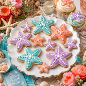 Op de afbeelding: Een verzameling stervormige koekjes versierd met taling, paars en koraalkleurig glazuur met witte gestippelde details. De koekjes zijn gerangschikt op een wit geschulpt bord naast cupcakes en een bordje met de tekst Sally Air Sunshine Starfish Wishes.