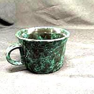 May include: A handmade ceramic mug with a textured, mottled green and brown glaze. The mug has a rounded shape, a handle, and a white interior. The mug is approximately 4 inches tall.