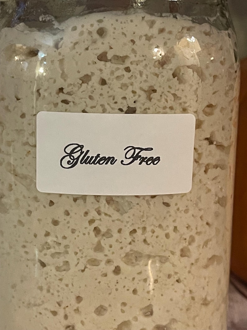 May include: A glass jar filled with a white, bubbly substance. A white label on the jar reads "Gluten Free".