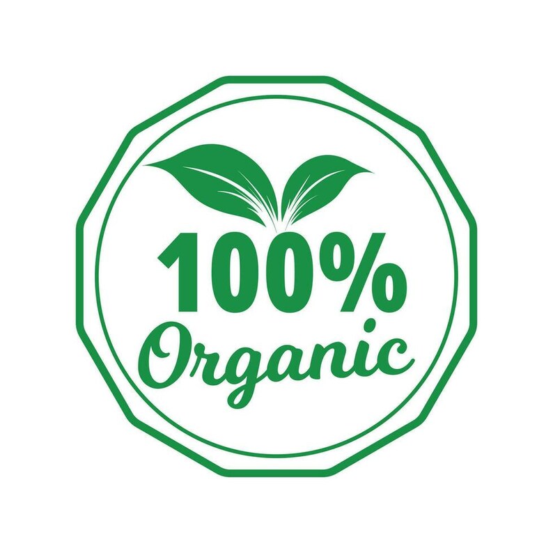 May include: A green and white circular emblem with the words "100% Organic". The emblem features two green leaves at the top and is surrounded by a green octagonal border.