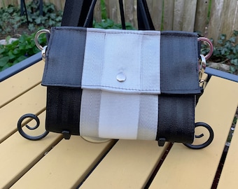 The Foldover Crossbody Clutch Seat Belt Bag, In Black Silver and White