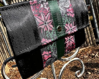 The Foldover Crossbody Clutch Seat Belt Bag in Black and Pink Floral
