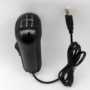 K&ouml;nnte beinhalten: Ein schwarzer USB-angeschlossener Schalthebel mit einem schwarzen Kunststoffgriff und einem silbernen Schaltmuster. Der Schalthebel hat die Zahlen 1 bis 8 und den Buchstaben R aufgedruckt.
