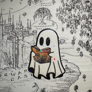 May include: A white ghost holding a copy of "Harry Potter" in a black frame against a black and white map of Hogwarts.