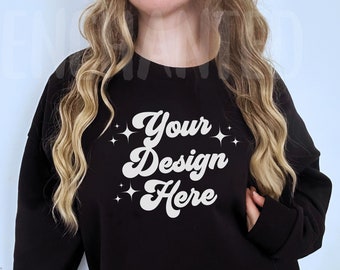 Puede incluir: Sudadera negra de manga larga con un gráfico blanco que dice "Your Design Here" con estrellas alrededor del texto.