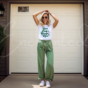 May include: A white t-shirt with a green shamrock design and the text "Your Patty's Design Here". The person is wearing green pants and sunglasses.