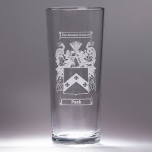 May include: A clear glass with an etched design of a coat of arms. The text reads "The Ancient Arms of Peck".