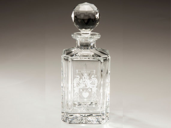 Hand-engraved crystal decanter with a custom family crest — the kind of heirloom-feeling gift that looks like it came from a Downton Abbey prop room.