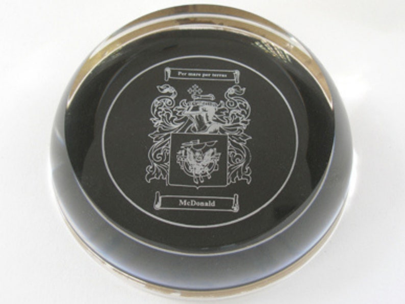 Peut inclure: Un presse-papier en verre noir avec un bord argent&eacute; et un blason grav&eacute; en argent avec le texte "Per mare per terras" et "McDonald".